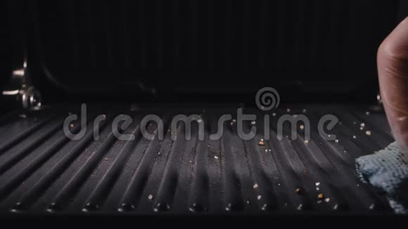 肮脏的电烤架男性用布烤架擦拭用抹布清洗电动烤架脏盘细节在人身上视频的预览图