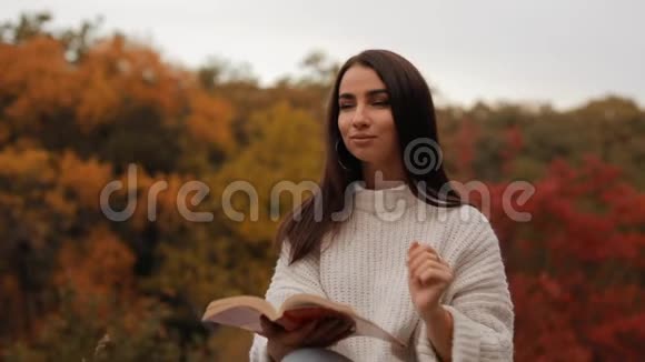 女子看书坐在秋林中头靠在手上视频的预览图