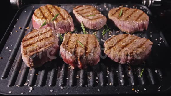美味多汁的肉排在烤架上烹饪牛肉煎煮后缓慢倒入盐迷迭香黑胡椒视频的预览图