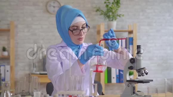 在实验室工作的戴着国家围巾的穆斯林女科学家化学家视频的预览图