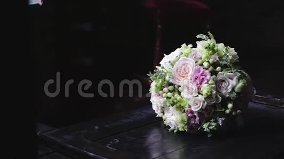 漂亮的婚礼花束放在黑色木制桌子上有选择性的灯光婚礼的概念视频的预览图