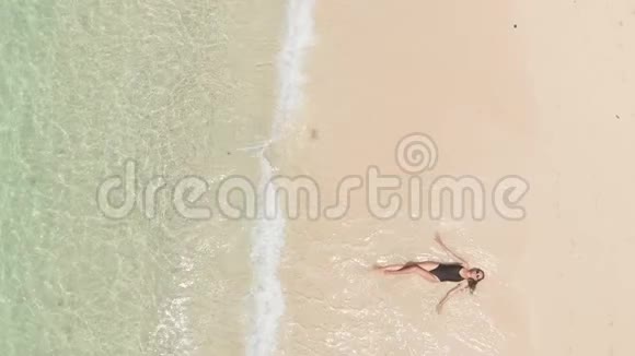上图为快乐微笑的女性穿着黑色比基尼戴着太阳镜在沙滩上享受夏日的海浪视频的预览图