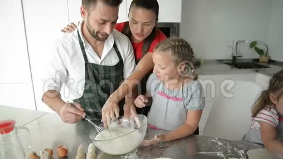 可爱的家庭一起在厨房做饭孩子们帮助父母视频的预览图
