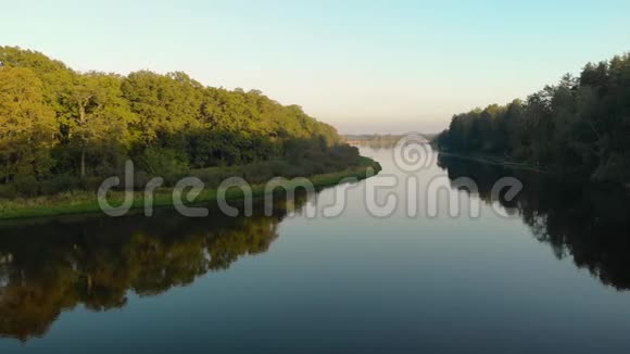 一架无人机在蜿蜒的河流上飞过一个风景名胜区它反映了巨大而茂密的树木视频的预览图