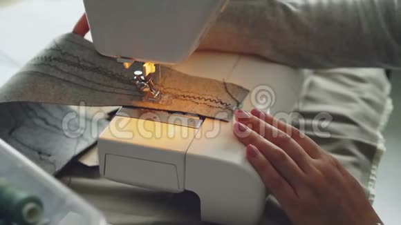 近景现代电动缝纫机工作缝片面料女孩修剪的手和五颜六色视频的预览图
