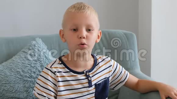 小男孩咳嗽坐在客厅的沙发上视频的预览图