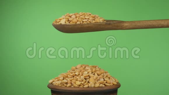 动作缓慢干的豌豆粒从一个木勺上得到足够的睡眠在一堆泥土碗里的种子视频的预览图
