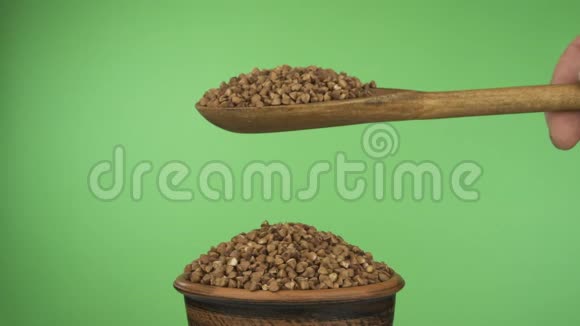 动作缓慢荞麦谷物从一个木勺上得到足够的睡眠在一堆泥土碗里的种子视频的预览图