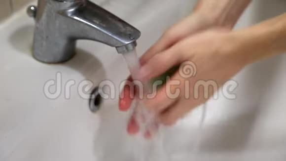 女人用肥皂在自来水下洗手预防病毒视频的预览图