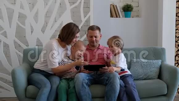 在家客厅使用数字平板电脑的快乐白种人家庭视频的预览图