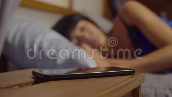 睡在床上的女人被手机吵醒视频的预览图