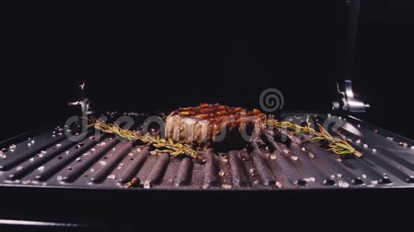 美味多汁的肉排在烤架上烹饪陈年珍贵烤大理石牛肉电烤炉迷迭香视频的预览图