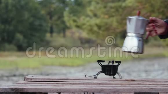在美丽的大自然背景下一台间歇喷泉咖啡机矗立在燃烧器上森林中的娱乐活动视频的预览图