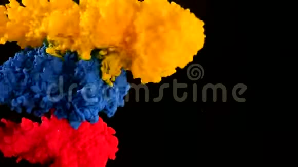 黄色蓝色和红色水彩墨水在水中的黑色背景上视频的预览图