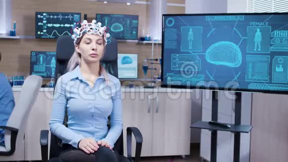 坐在椅子上戴脑电波扫描耳机的年轻女性患者视频的预览图