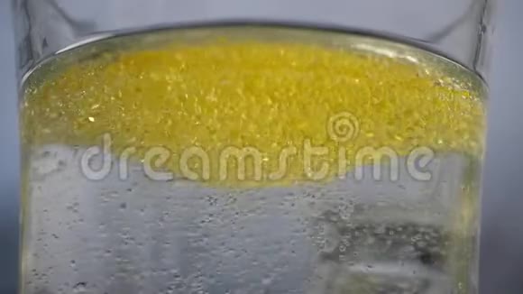 许多黄色的气泡和灯泡漂浮在玻璃中在特写镜头中有清澈的水水中的油会变成气泡视频的预览图