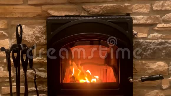 明亮的橙色火焰燃烧在黑色壁炉舒适的家庭概念视频的预览图