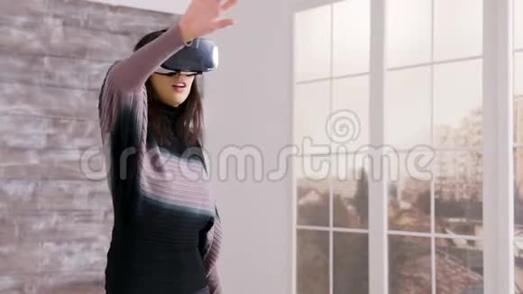 漂亮的女家庭设计师使用虚拟现实护目镜视频的预览图