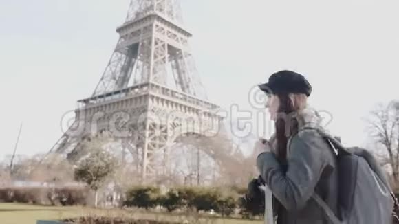 侧面观看快乐自由摄影师妇女走在秋天巴黎街道埃菲尔铁塔度假慢动作视频的预览图