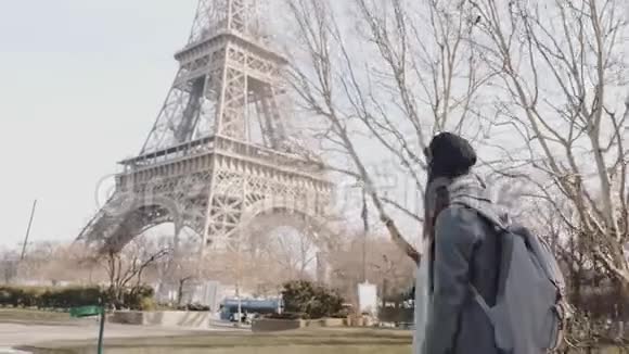 镜头跟随快乐的自由职业者妇女走在秋天的巴黎街道附近埃菲尔铁塔出差慢动作视频的预览图