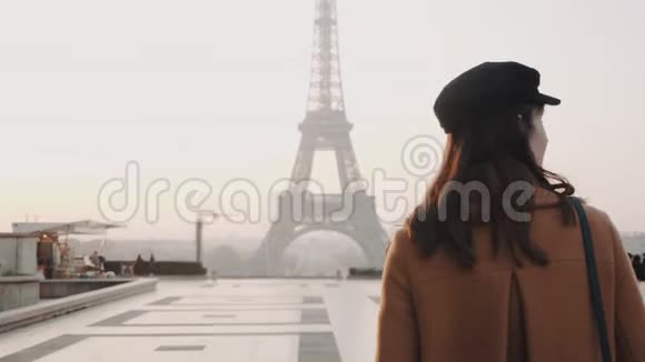 镜头跟随美丽的旅行者女人走向雾蒙蒙的埃菲尔铁塔在特罗卡德罗巴黎度假慢动作视频的预览图