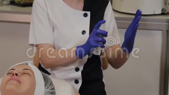 专业美容师用防腐剂处理蓝色橡胶手套视频的预览图