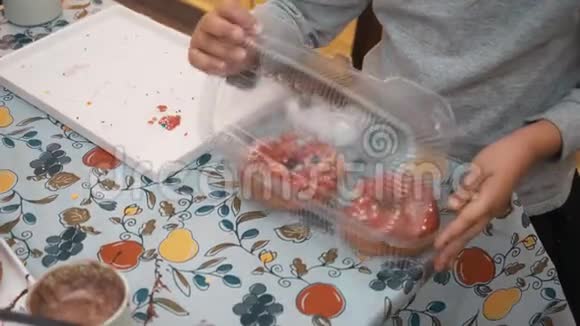 年轻女孩用新鲜巧克力甜甜圈准备午餐盒可爱的女孩用甜甜甜圈和视频的预览图