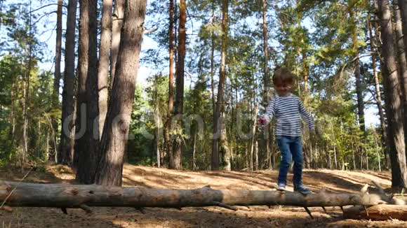 快乐的孩子花时间在公园或森林的户外玩耍活跃的男孩正走在横梁上克服障碍视频的预览图