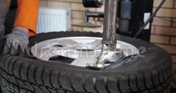 维修工用专用工具将轮胎安装在汽车车轮上修理工使用安装工具进行轮胎修理视频的预览图