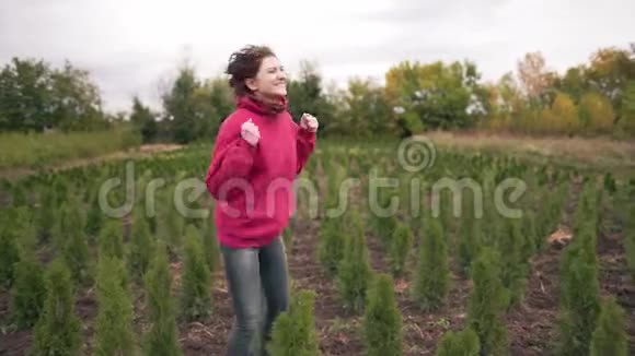 成功在针叶树旁边的一个田野里的女花匠以一种很大的顺序高兴快乐女企业家老板视频的预览图