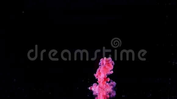 五颜六色的颜料滴在水里慢动作墨云隔离黑背景视频的预览图