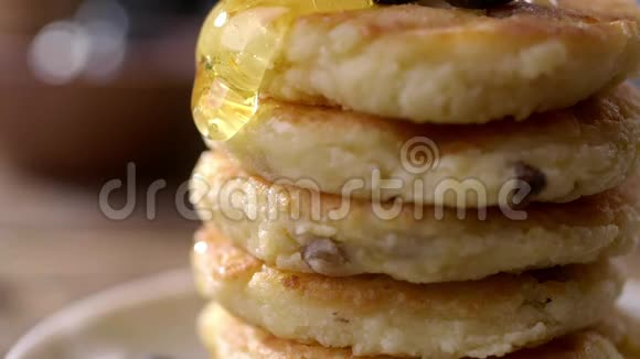 带有葡萄干和流动蜂蜜的煎饼慢动作烹饪和进食美味的早晨早餐特写食物视频的预览图