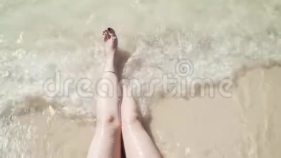 女人双腿被泡沫般的海浪拍打着视频的预览图