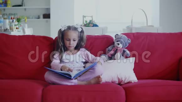 可爱的小孩坐在沙发上看书视频的预览图