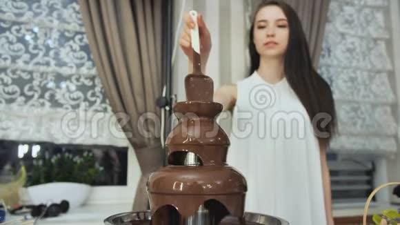 女孩在庆祝活动中搅动了一个巧克力喷泉视频的预览图