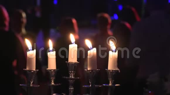 在夜总会里在烛台上点燃蜡烛在跳舞的人附近视频的预览图
