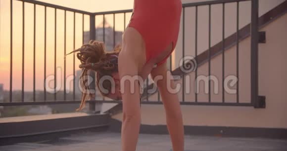 一张精神女性的特写照片戴着可怕的锁在做瑜伽看着镜头在屋顶上开心地笑着视频的预览图