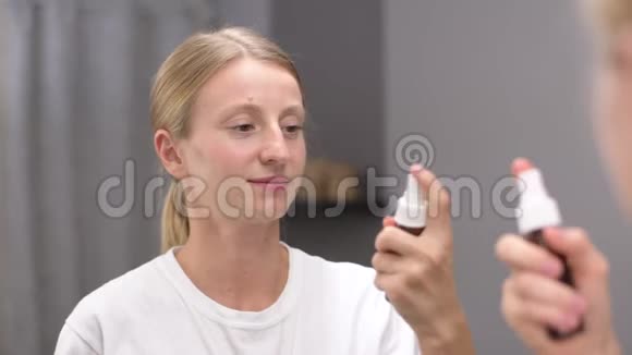 你的面部护理美丽的女人在脸上喷着微波视频的预览图