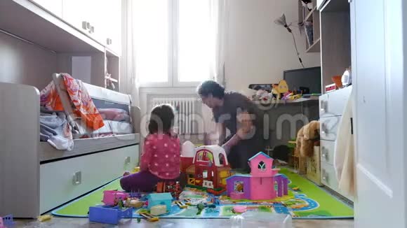 父亲和女儿从玩具中打扫凌乱的女婴房间视频的预览图