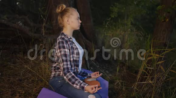 少女夜间在森林中冥想的侧景视频的预览图