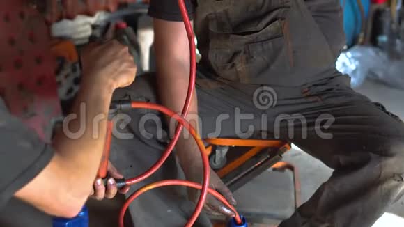 在汽车修理厂修理汽车的男机修工视频的预览图
