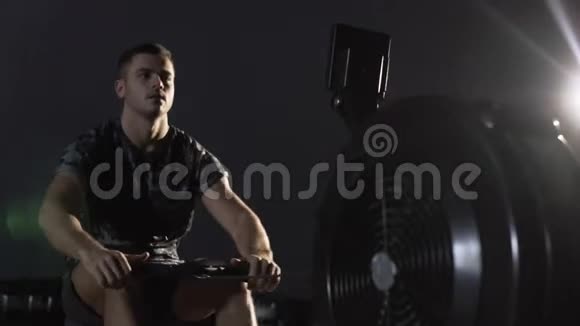 年轻的健身者在交叉健身房锻炼划船机视频的预览图