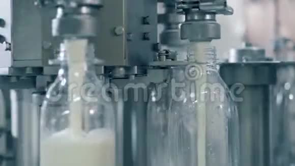 关闭牛奶通过工厂机器倒入瓶子视频的预览图