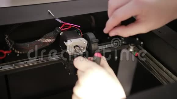 年轻人修理3D打印机修理调试工作的细节视频的预览图