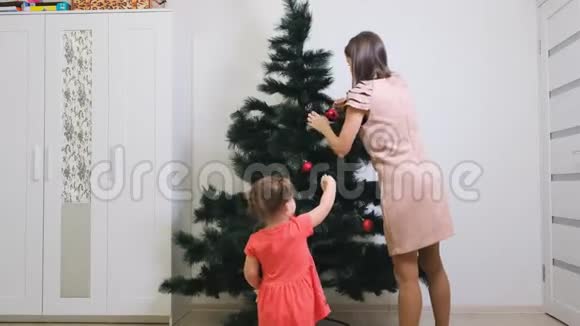 圣诞快乐假日快乐妈妈和女儿在室内装饰圣诞树圣诞节前的早晨视频的预览图