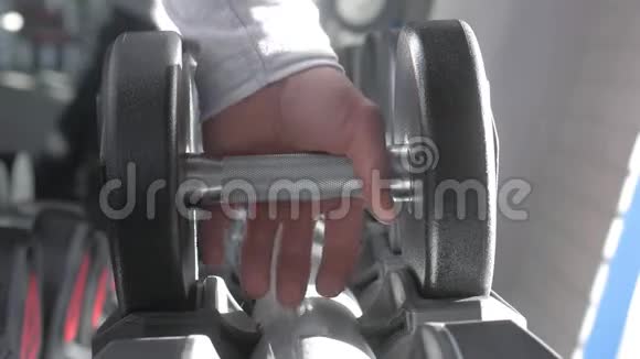 一个人手在健身房拿一个哑铃快关门健身房里肌肉发达的手臂训练运动手哑铃这就是视频的预览图