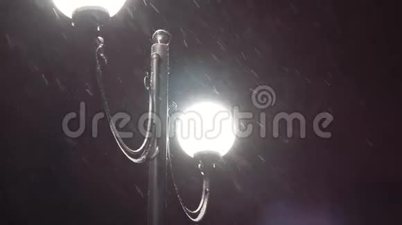 圣诞夜降雪中的城市灯笼夜幕降临的冬日路灯视频的预览图
