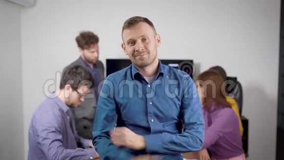 有创意的商业朋友一个迷人的微笑男人的肖像在他的伙伴和朋友的背景下视频的预览图