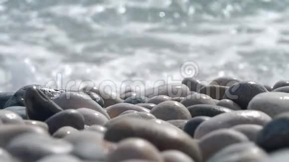 靠近岸边的岩石海滩卵石和起伏的绿松石海波飞溅视频的预览图