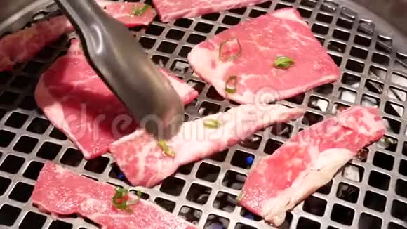 中餐厅餐桌上人们烧烤肉的动作视频的预览图